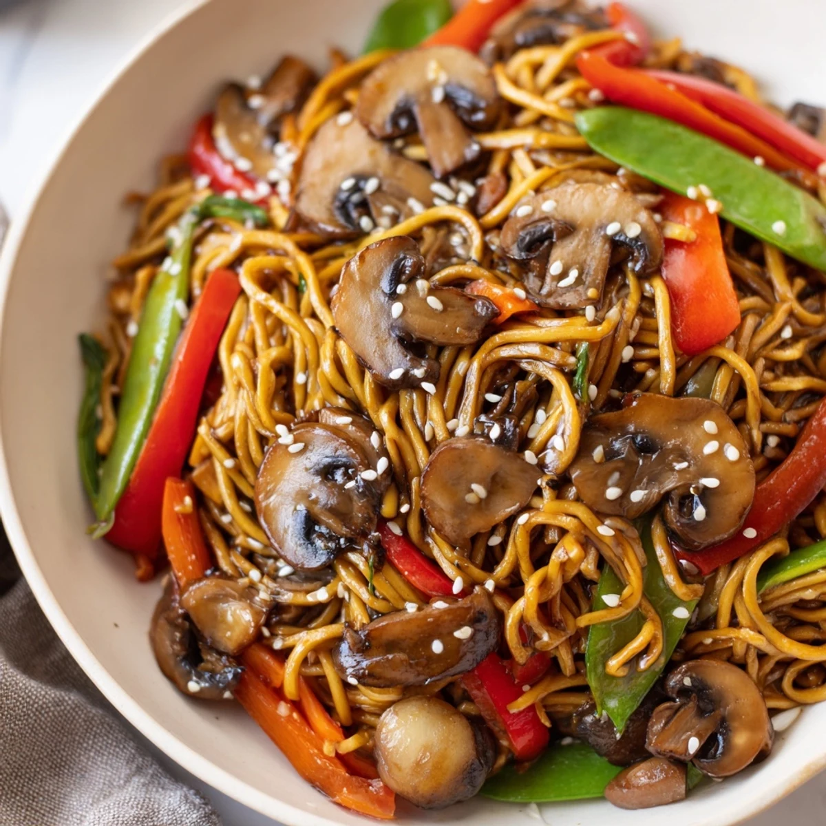 Golden garlic mushroom chow mein noodles tossed with colorful crisp vegetables in a savory soy-based sauce