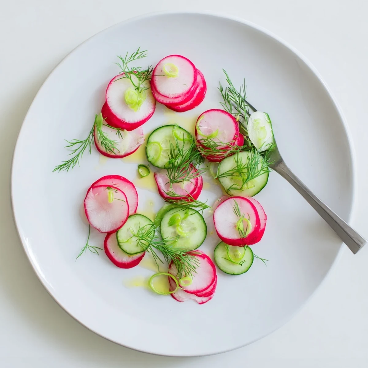 Colorful radish and cucumber salad featuring thinly sliced vegetables and fresh herbs for summer side dish