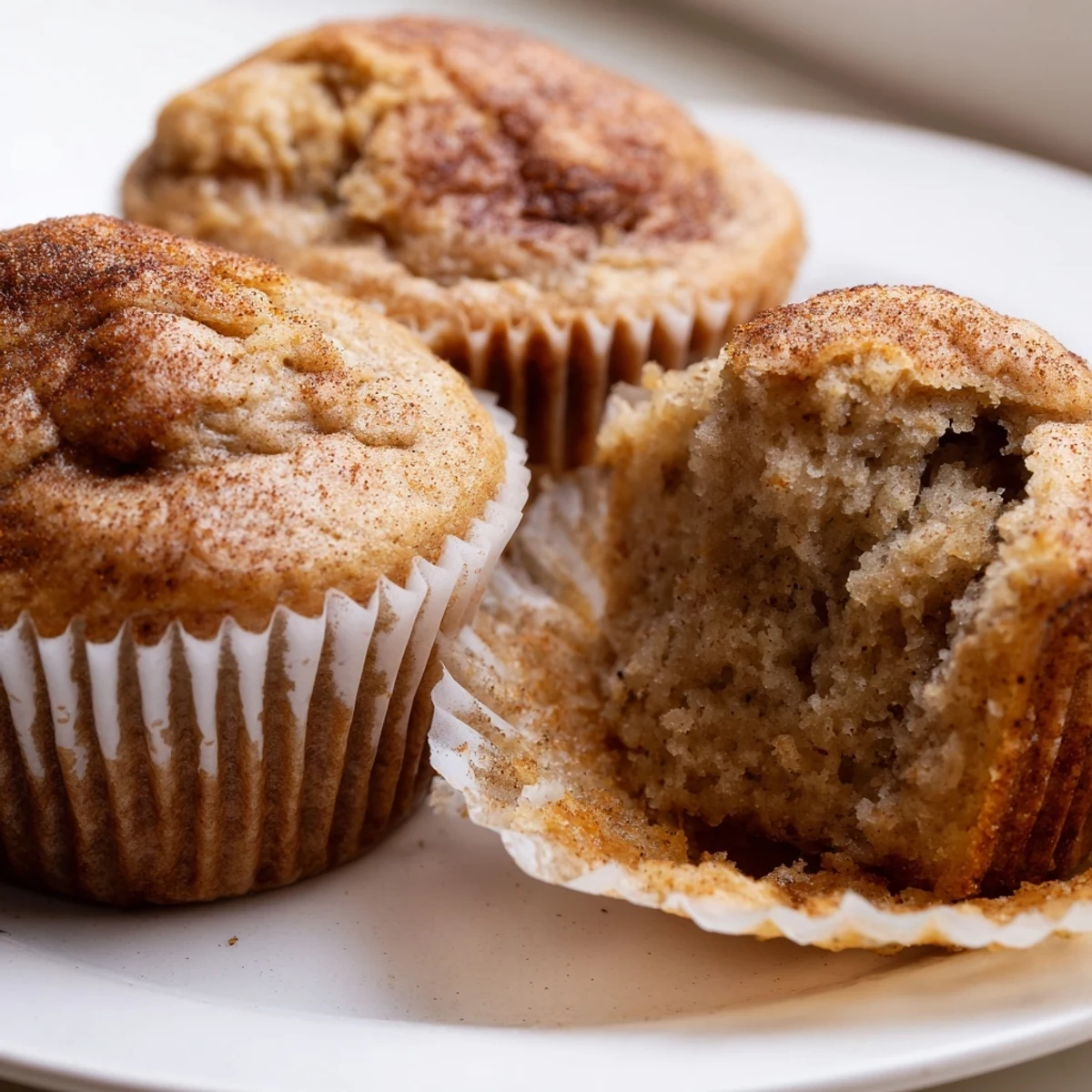 Golden banana muffins with domed tops cooling on a wire rack, soft and fluffy