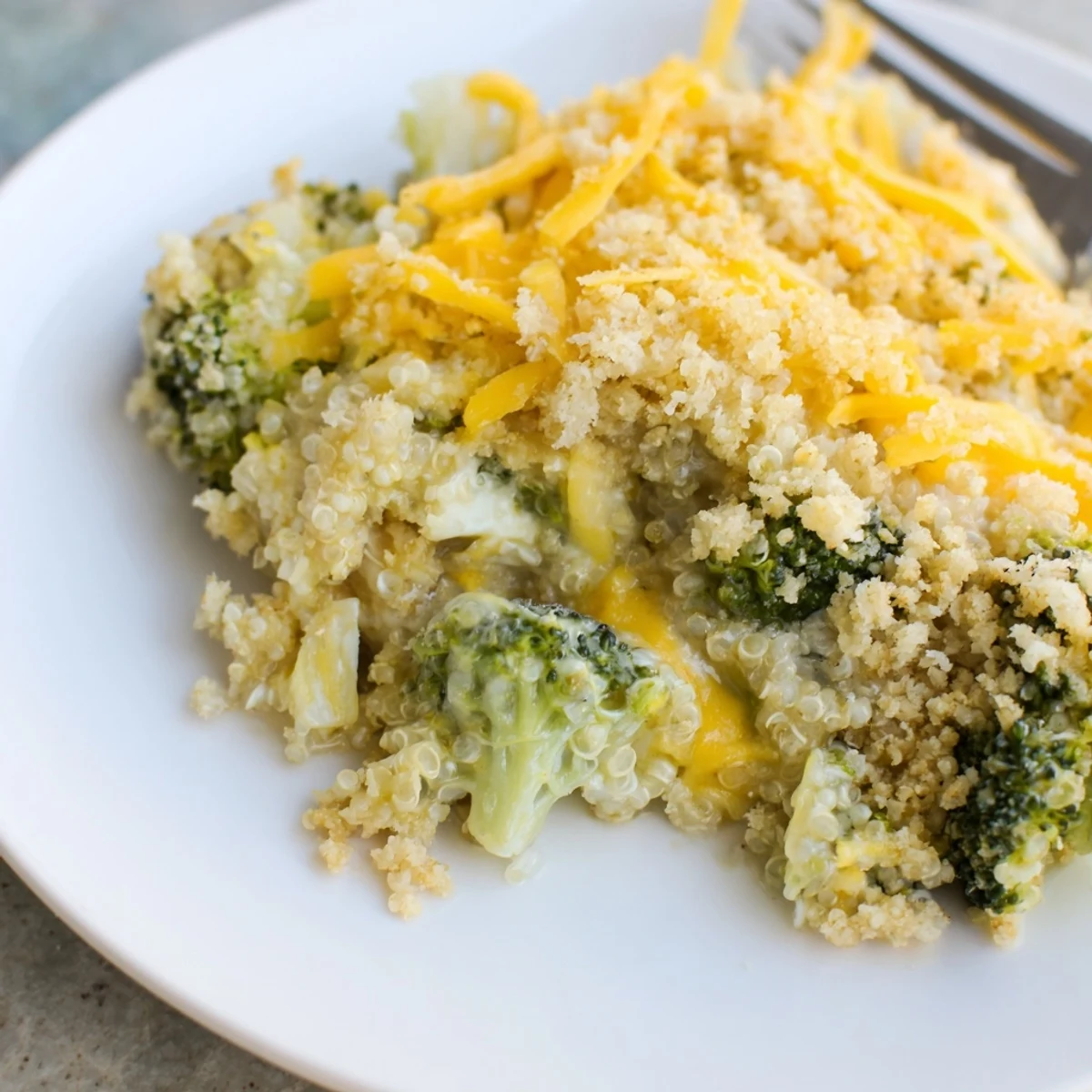Creamy broccoli quinoa casserole bubbling in a dish with crispy breadcrumb topping