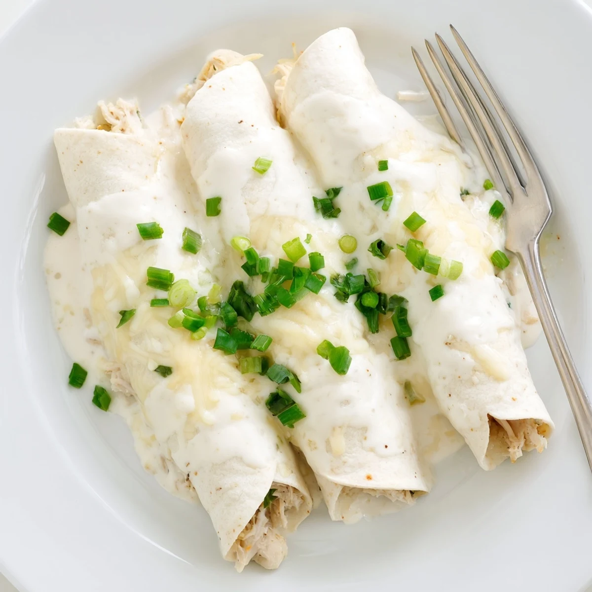 Baked Creamy White Chicken Enchiladas with velvety sauce, soft tortillas, savory aroma.