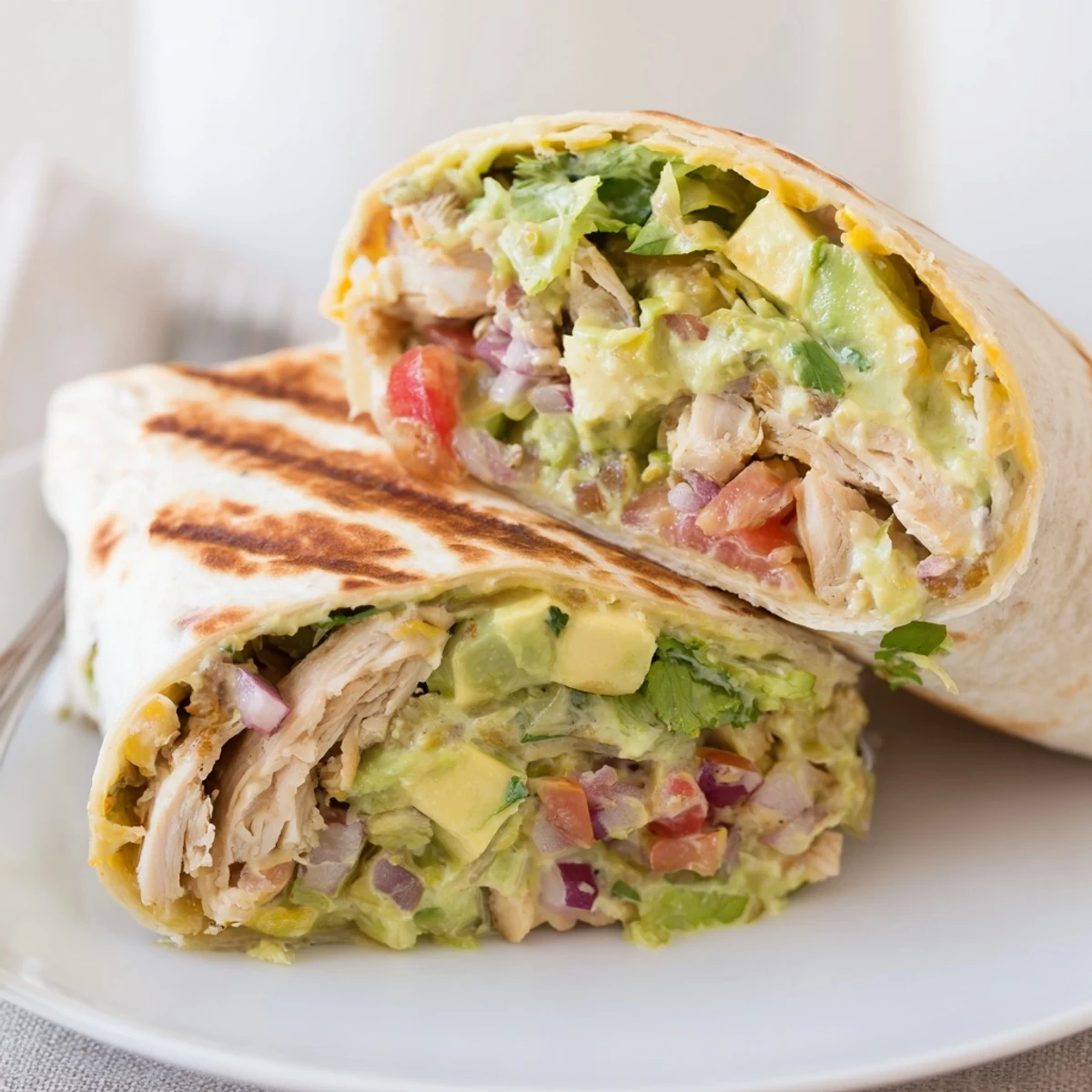 Golden-grilled Chicken Avocado Ranch Burritos served halved on skillet, toasty tortillas