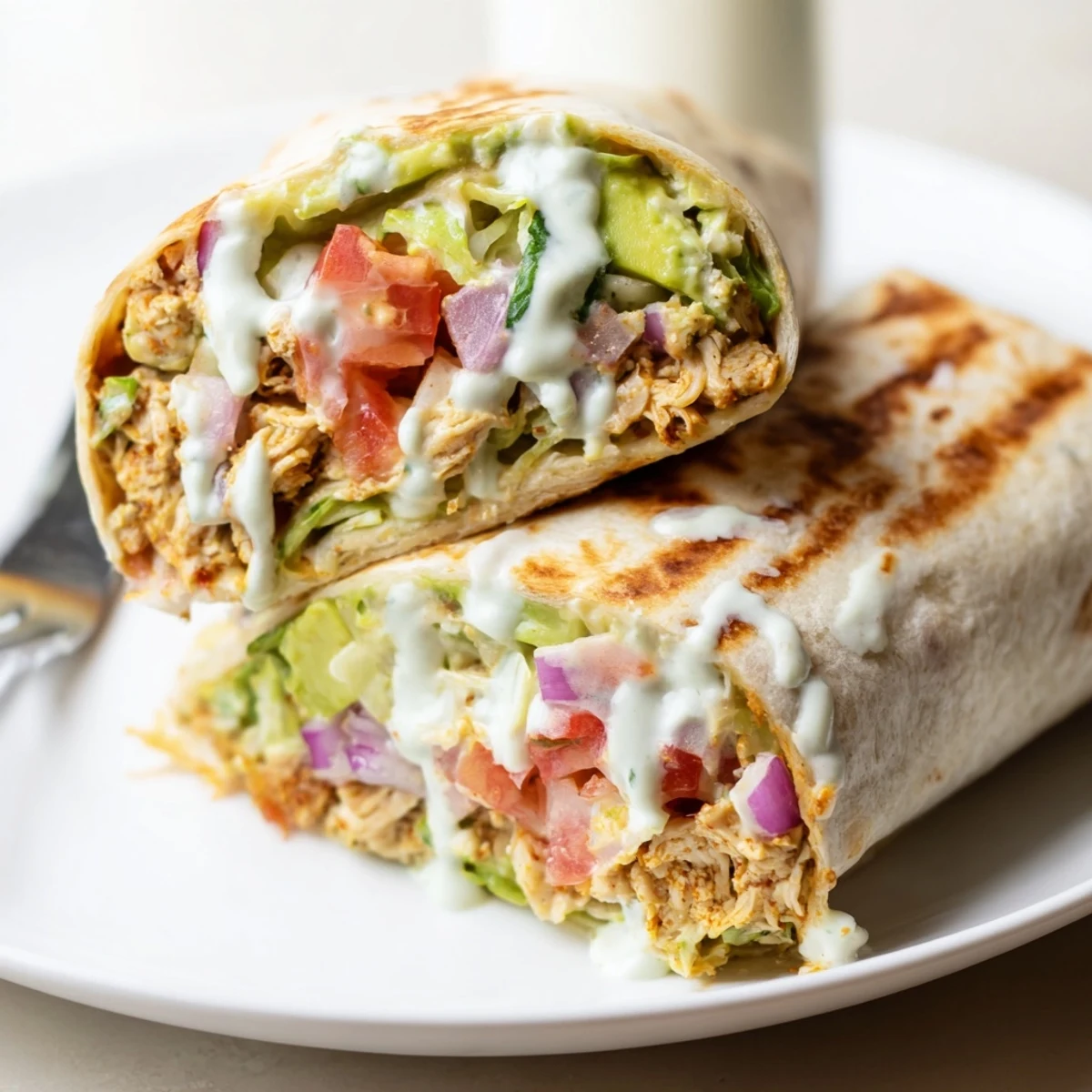 Quick weeknight Chicken Avocado Ranch Burritos drizzled with extra ranch, ready to eat