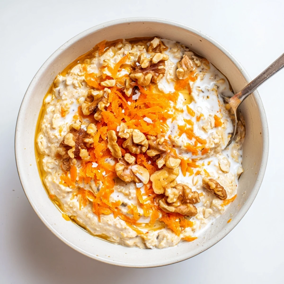 Hearty breakfast Carrot Cake Overnight Oats garnished with grated carrot and raisins.