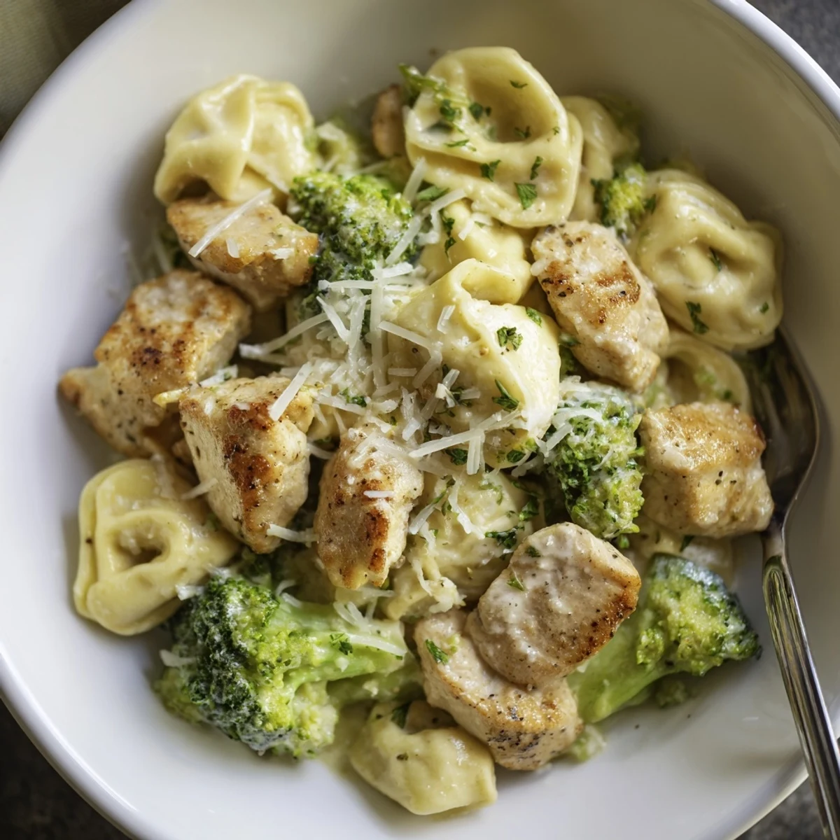 Skillet-style Creamy Garlic Parmesan Tortellini Chicken Broccoli Recipe served piping hot with chopped fresh parsley