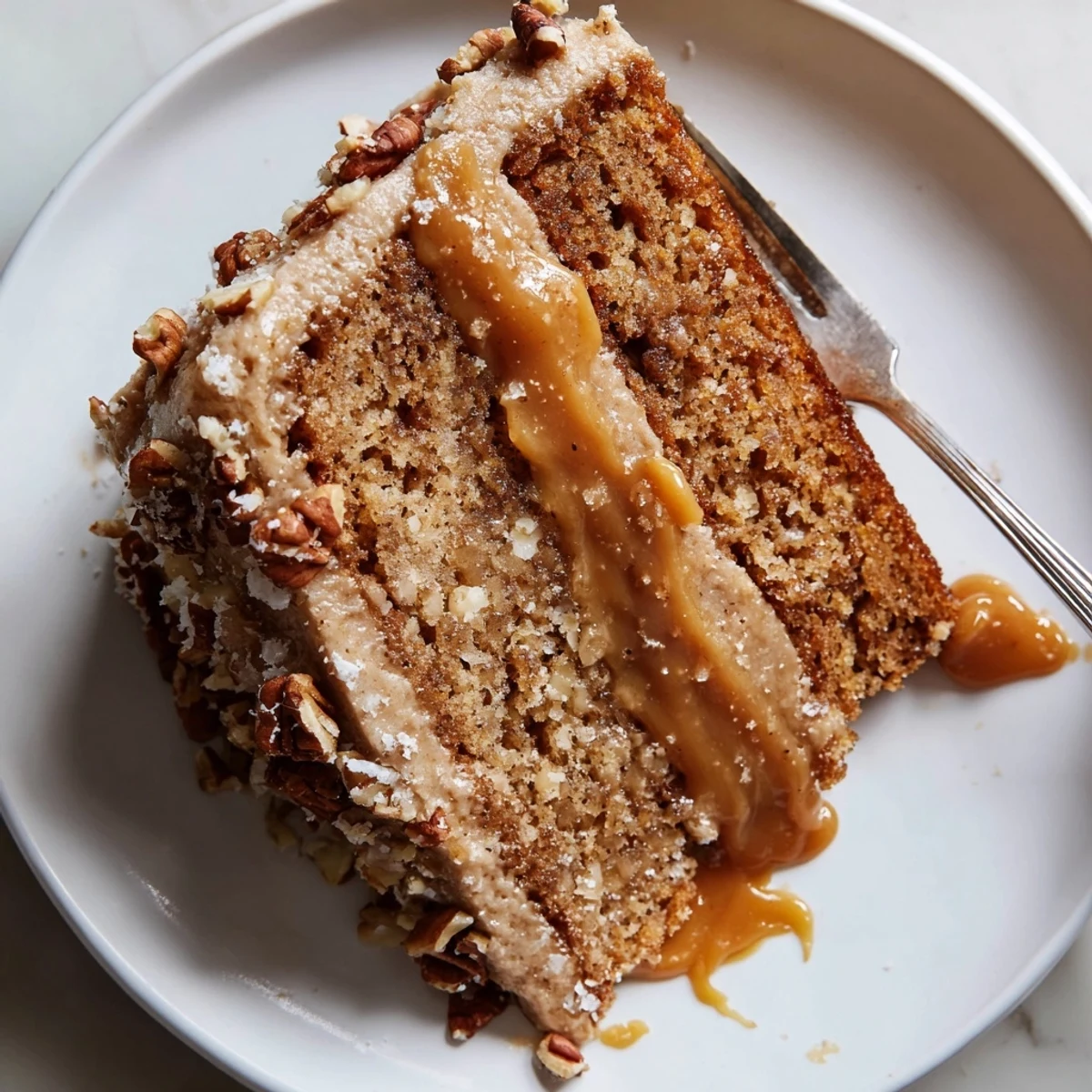 Warm slice of Salted Caramel Brown Butter Banana Cake served with whipped cream