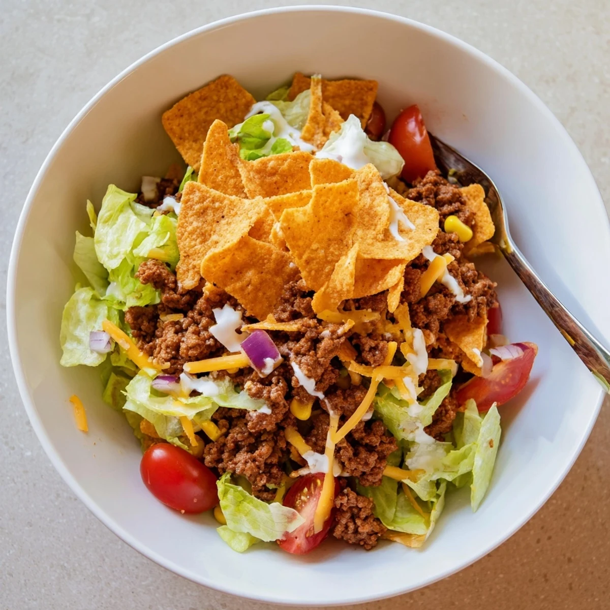 Simple Doritos Taco Salad with seasoned beef, cheddar, crisp romaine, fresh tomatoes