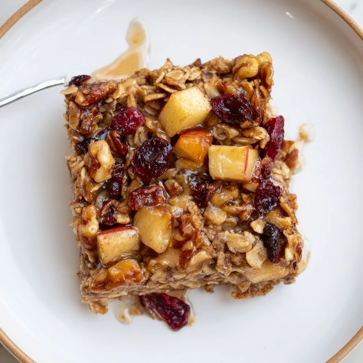 Spoon-ready Delicious Apple Cinnamon Oatmeal Bake Recipe For Mornings, steaming, apple chunks visible.