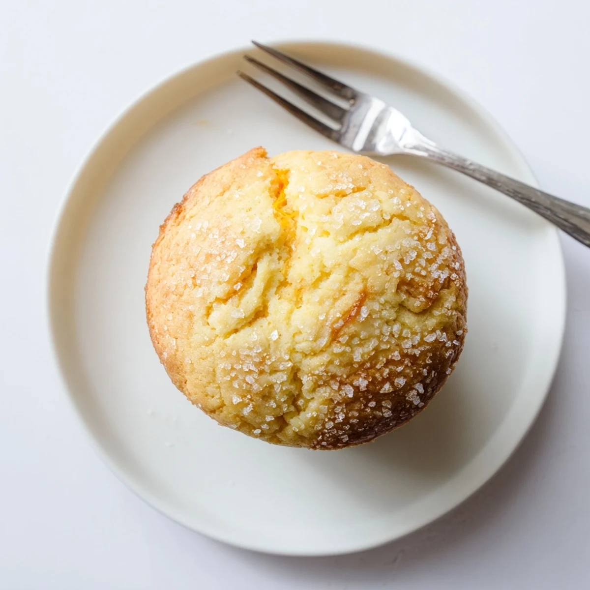 Freshly baked lemon cream cheese muffins cooling on wire rack with visible cream cheese center