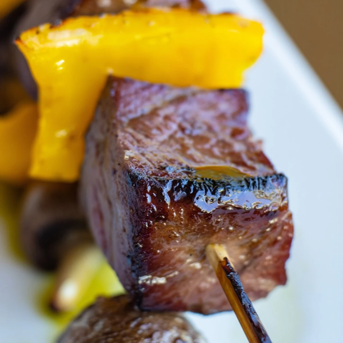 Juicy steak kebabs with colorful peppers and onions sizzling on a hot grill