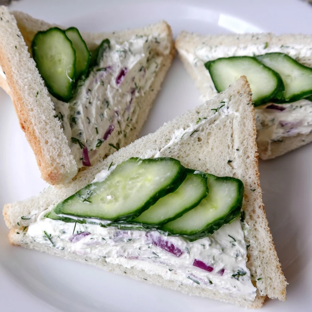 Tea-style cucumber salad sandwiches with herb cream cheese filling and thinly sliced vegetables