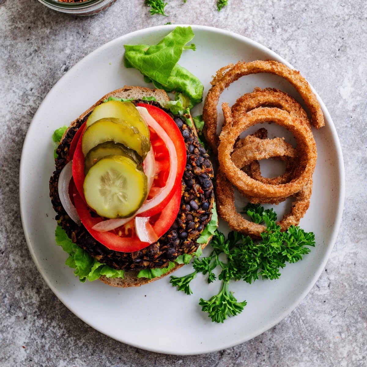 Homemade veggie burgers recipe plated with crispy sweet potato fries and pickles on the side