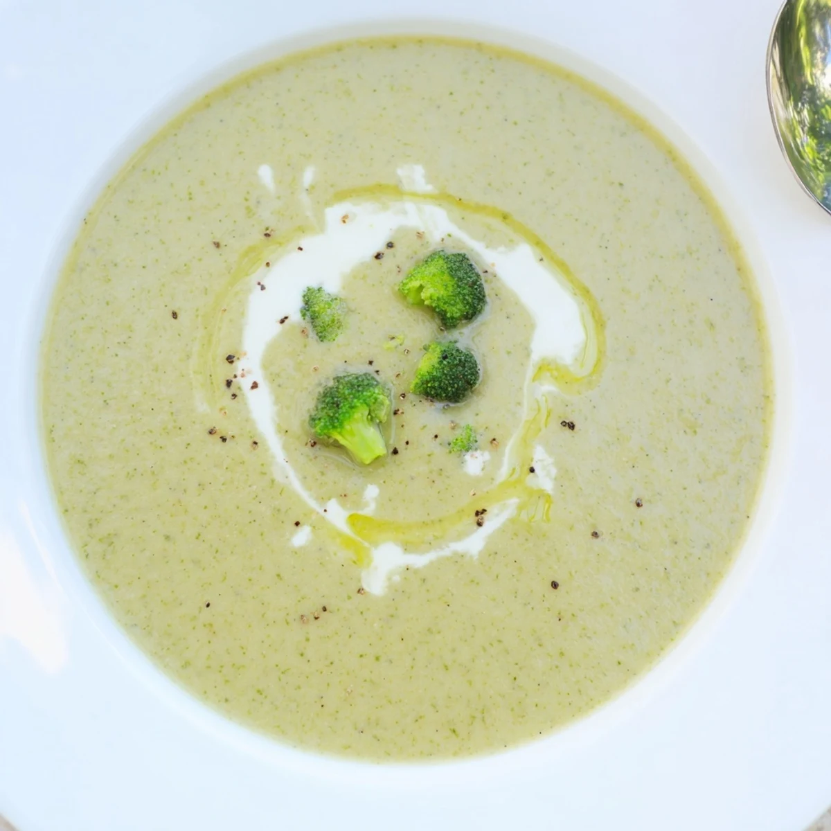 Creamy Broccoli Soup steaming in a bowl, garnished with cream swirl