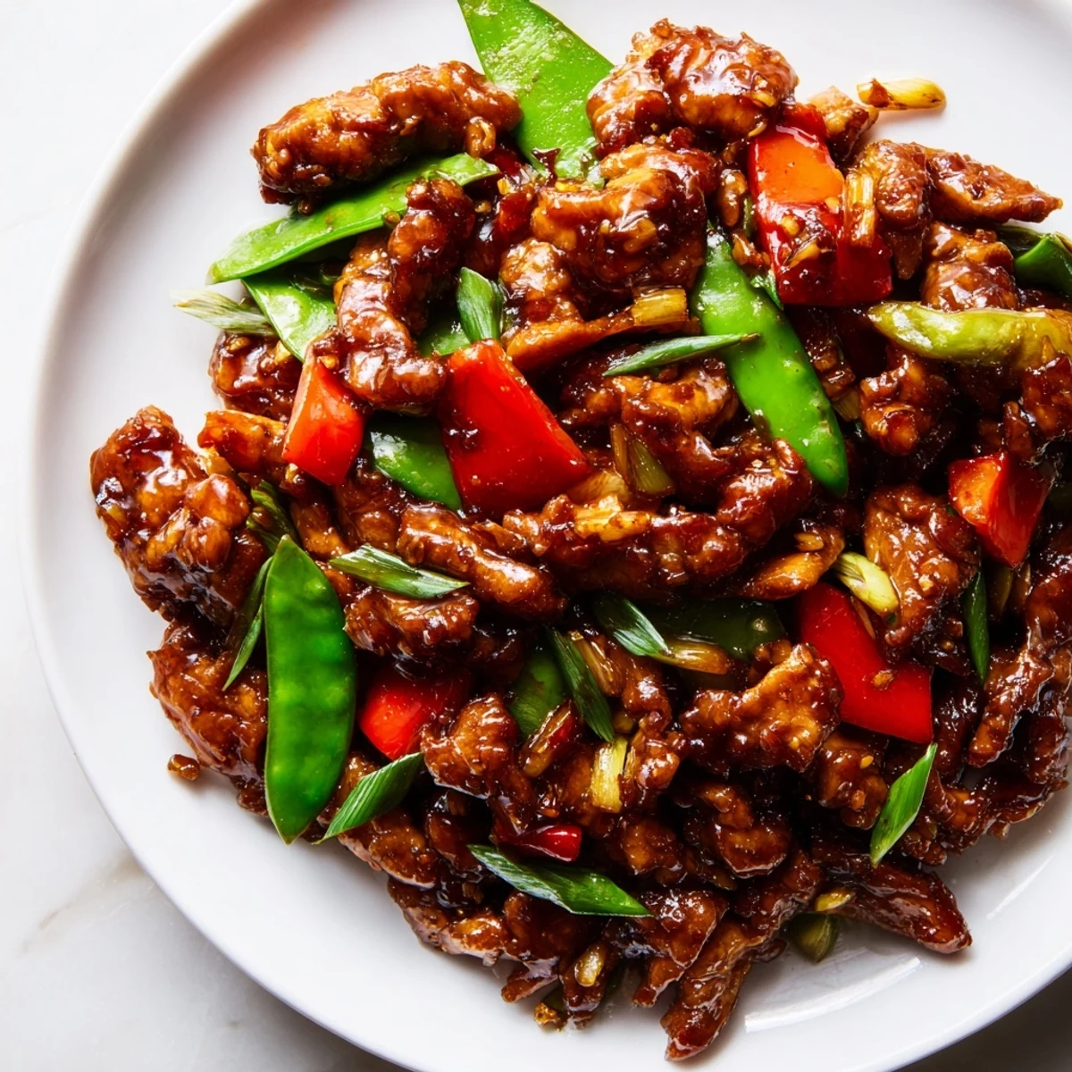 A vibrant plate of stir-fried Chinese garlic chicken drizzled with glossy garlic soy sauce