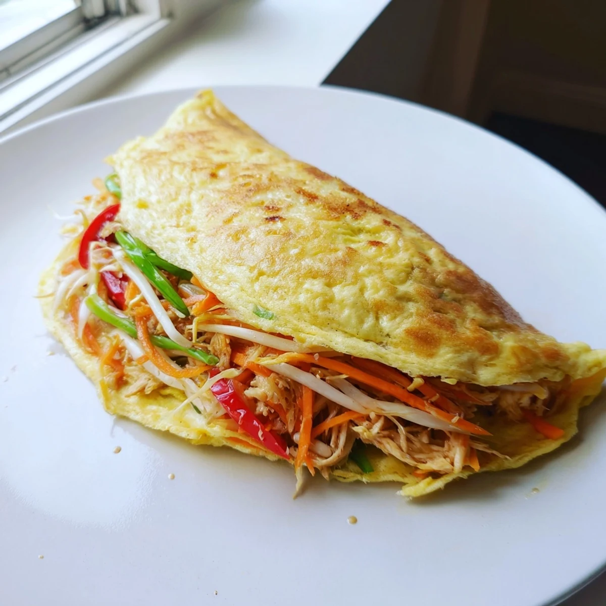 Fluffy Chinese omelette filled with colorful bell peppers, bean sprouts, and chicken