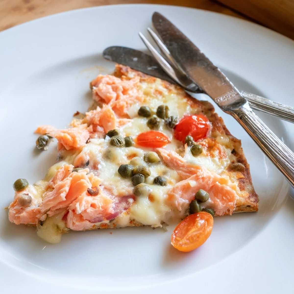 Golden leftover salmon tortilla pizza on a baking sheet, sliced and ready to serve.