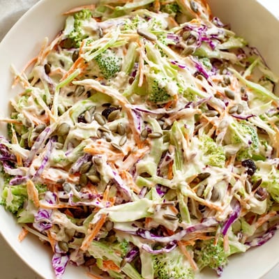 Bright and crunchy broccoli slaw tossed in tangy dressing topped with sunflower seeds